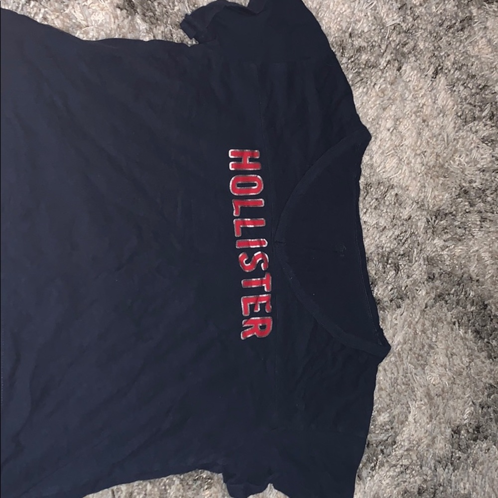 blue cropped shirt with red and gold letters